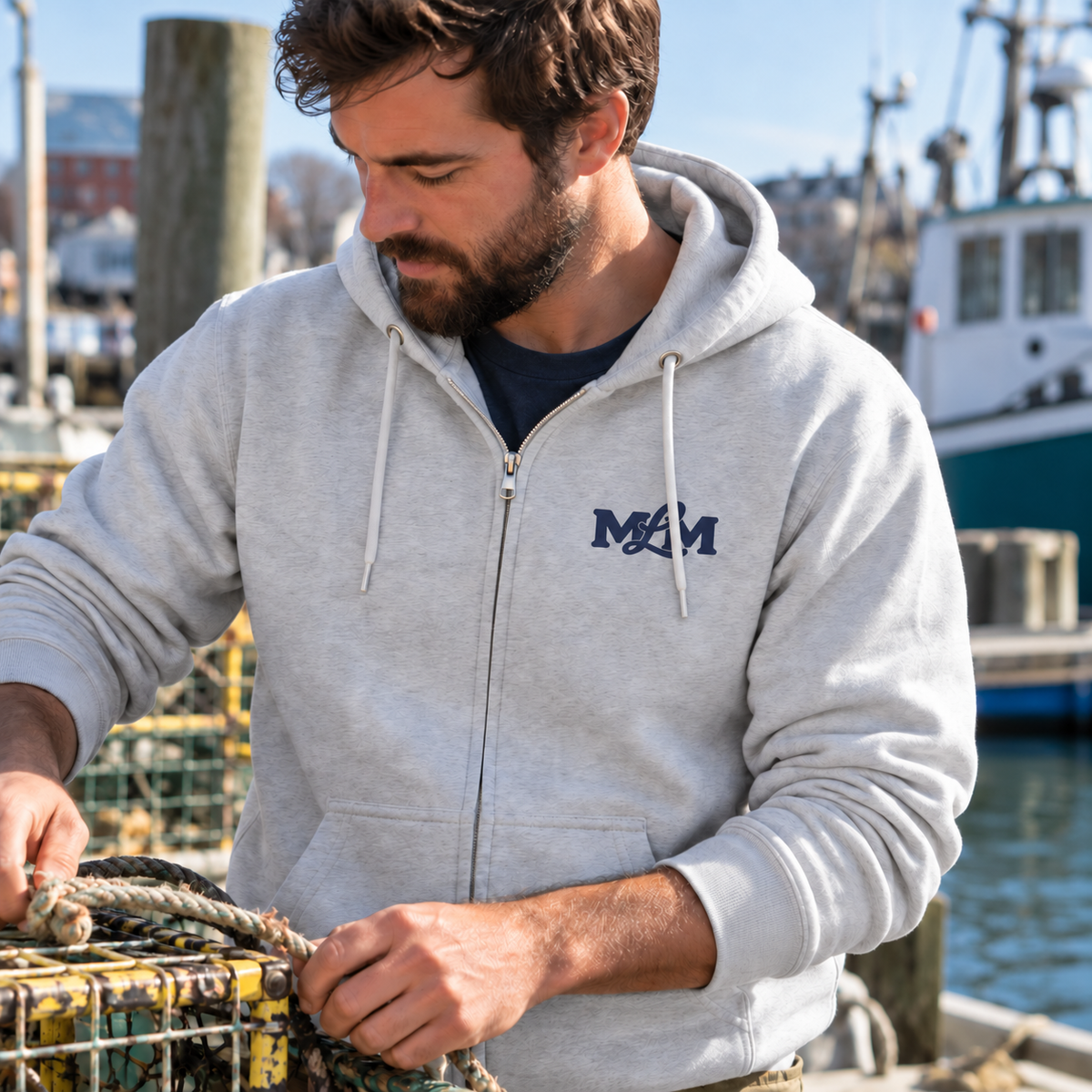 The Campfire Zip Hoodie in Heather Grey with navy MLM monogram, men’s lifestyle photo