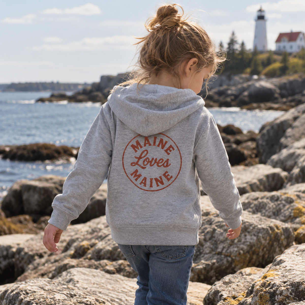 Gray Ember Zip Hoodie with rust Maine Loves Maine back logo on the Maine coast